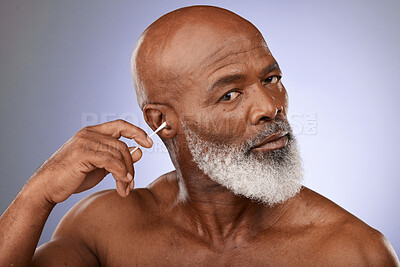 Buy stock photo Black man, cleaning ear and cotton bud for hygiene, wellness and wax with face, portrait and purple studio background. Senior male with ears, cleaner and self care for earwax , remove and stick