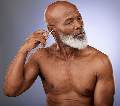 Buy stock photo Cotton bud, black man and cleaning ear on studio purple background for wellness, healthy skincare and facial cosmetics. Mature guy remove wax from ears for personal hygiene, grooming and body care 