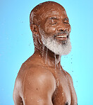 Studio, water and old man in a shower cleaning his face or body for skincare beauty or wellness on a blue background. Smile, healthy or happy elderly male model washing or relaxing with mock up space
