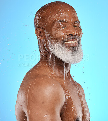 Buy stock photo Studio, water and old man in a shower cleaning his face or body for skincare beauty or wellness on a blue background. Smile, healthy or happy elderly male model washing or relaxing with mock up space