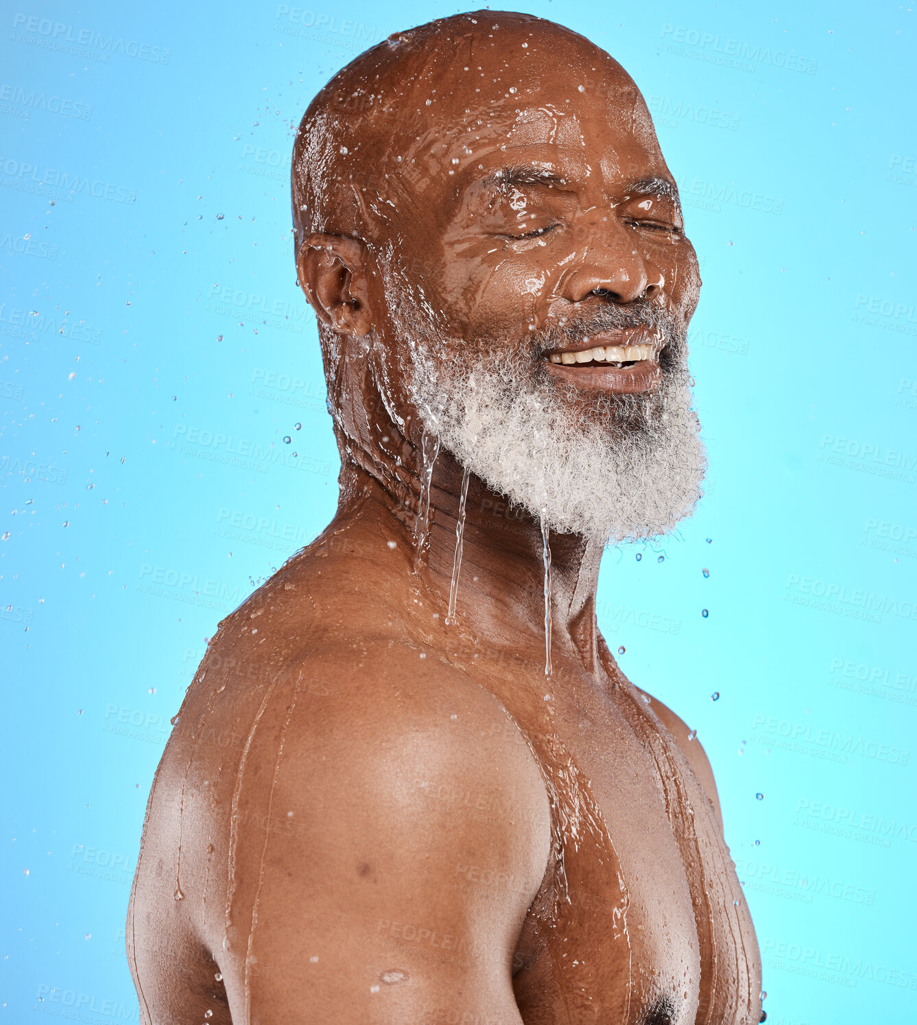 Buy stock photo Studio, water and old man in a shower cleaning his face or body for skincare beauty or wellness on a blue background. Smile, healthy or happy elderly male model washing or relaxing with mock up space
