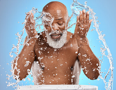 Buy stock photo Water splash, skincare and black man in studio for cosmetics, dermatology and facial cleaning in bathroom mockup. Water drops, senior man model for face wash, skin care in morning on blue background 