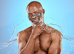 Skincare, water and facial for black man on blue background for wellness, hydration and spa. Dermatology, beauty and portrait of elderly male with skincare products, facial mask and water splash