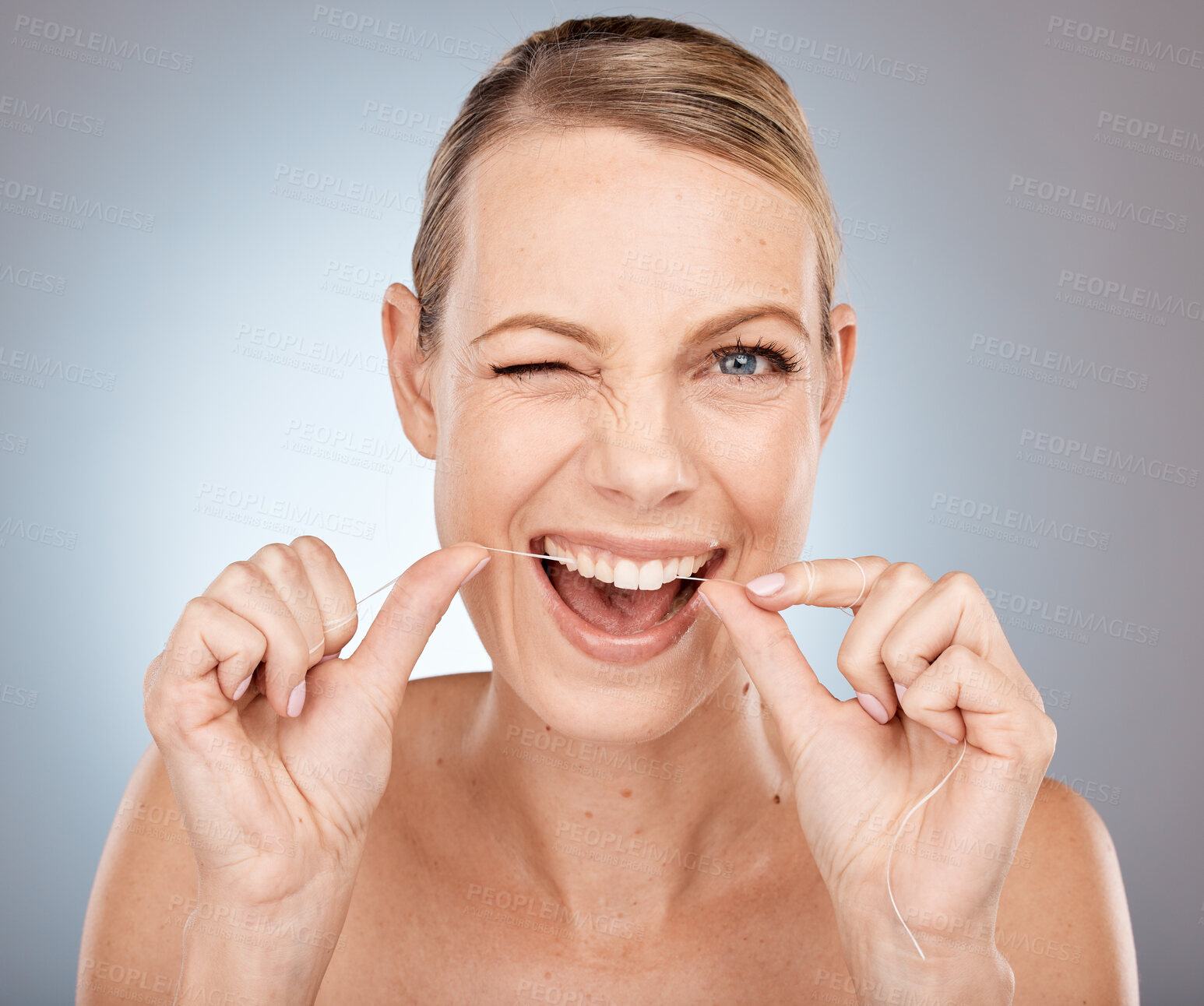 Buy stock photo Smile, wink and woman flossing teeth, morning dental care routine on studio background. Health, wellness and happy woman with dental floss, motivation for cleaning a healthy mouth and fresh breath.