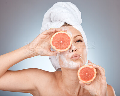 Buy stock photo Face, shower and orange with a model woman in studio on a gray background for natural skincare or healthy eating. Cleaning, facial and portrait with an attractive young female holding fruit for diet