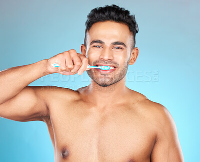 Buy stock photo Man, brushing teeth and studio for health, dental care and beauty with smile on face by blue background. Model, portrait and cleaning teeth for hygiene, wellness and healthcare by for healthy mouth