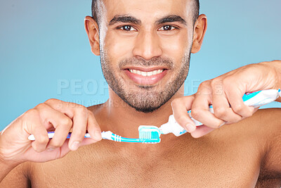 Buy stock photo Portrait, man and brushing teeth with toothpaste, toothbrush and dental wellness for healthy lifestyle, cleaning or cosmetics on blue background in Turkey. Happy male model, oral mouth care and smile