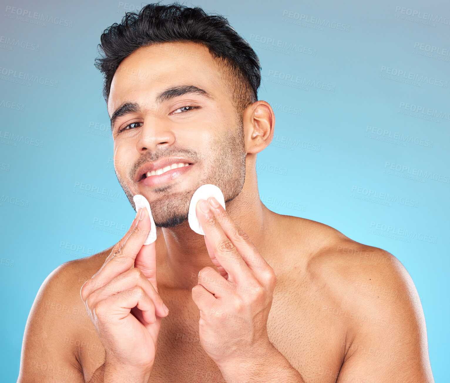 Buy stock photo Man, skincare portrait and cotton pad in studio for beauty, wellness or cosmetic self care with smile. Happy, model face and cottonwool for cleaning, cosmetics or healthy aesthetic by blue background