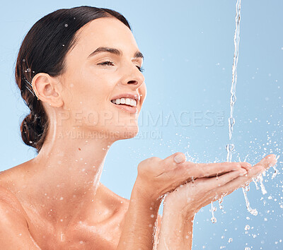 Buy stock photo Woman, hands and cleaning in studio for skincare, water and splash against blue background mockup. Girl, relax and shower with beauty splash in a bathroom for wellness, washing and hydration product