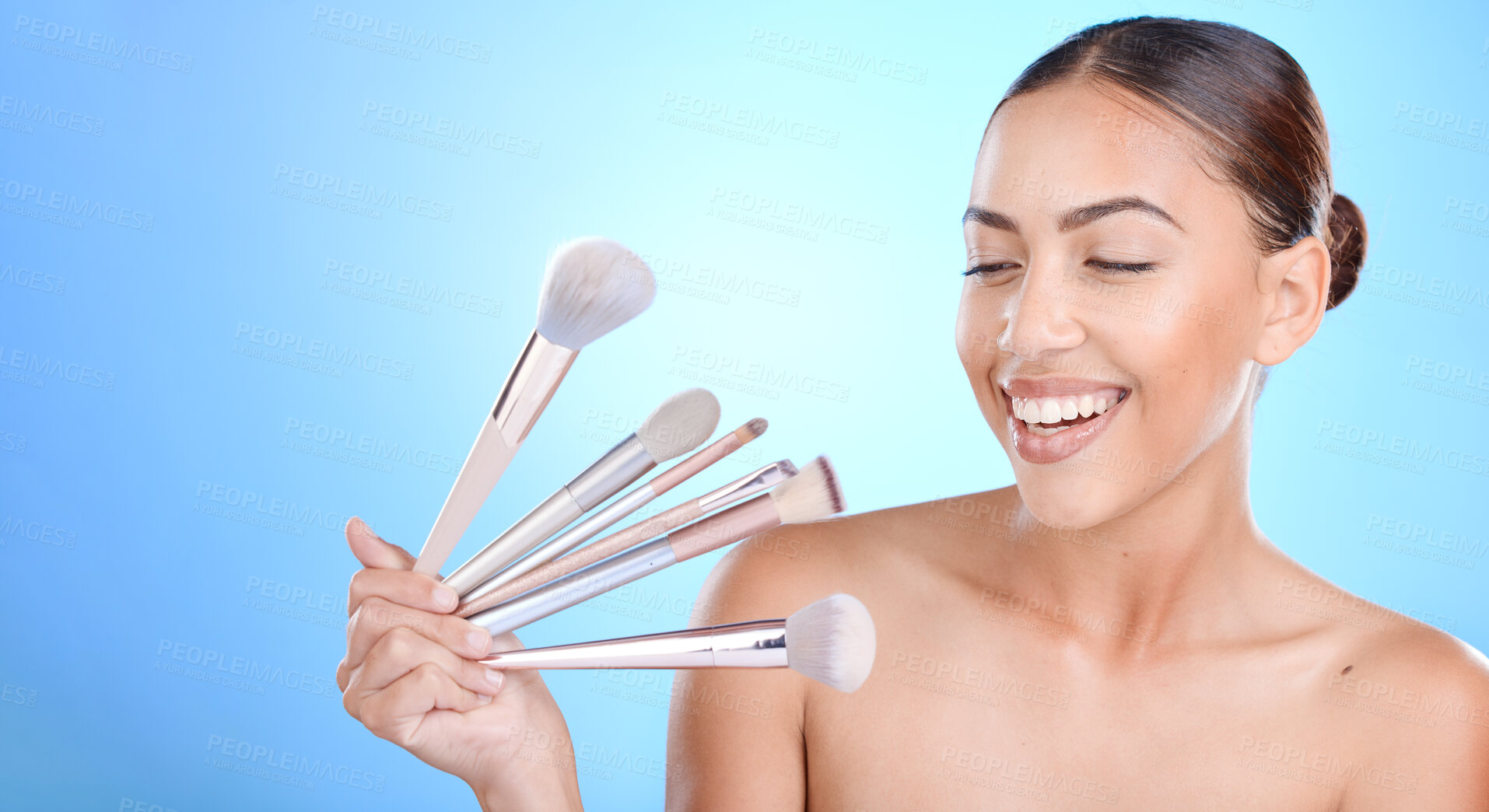 Buy stock photo Makeup, brush and beauty woman in studio cosmetics, natural skincare and product promotion, marketing or advertising on blue mockup. Happy artist or model and choice of cosmetic tools for foundation