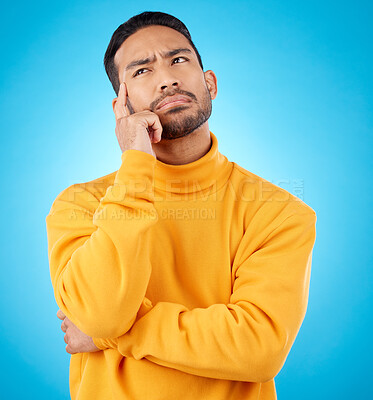 Buy stock photo Thinking, idea and young man in a studio with doubt, confused or choice facial expression. Problem solving, dream and Indian male model brainstorming, question or planning isolated by blue background