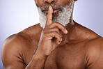 Senior man, skincare secret and face beauty in purple studio for luxury wellness, salon cosmetic care and black man dermatology. Elderly African person, finger on lips and natural facial or body care