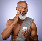 Skincare, beauty cream and black man studio portrait with a towel and lotion for cosmetics, self care and dermatology product on a purple background. Face of black male with a smile for healthy skin 