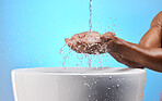 Black man, water splash and washing hands on blue background in studio hygiene maintenance, bacteria cleaning or healthcare wellness. Zoom, model and wet sink for skincare grooming in house bathroom