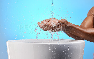 Buy stock photo Black man, water splash and washing hands on blue background in studio hygiene maintenance, bacteria cleaning or healthcare wellness. Zoom, model and wet sink for skincare grooming in house bathroom