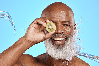 Buy stock photo Health, skincare and black man with kiwi, natural beauty or cosmetics on blue studio background. Portrait, retirement and senior male with fruit, wellness or organic facial for smooth and clear skin.