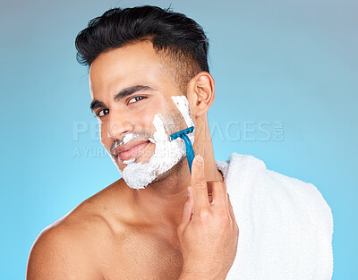 Buy stock photo Man, face and shaving in studio for skincare, wellness and towel in portrait by blue background. Model, facial hair removal and cosmetic cream for skin, self care and cleaning with cosmetics beauty