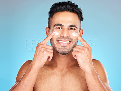 Buy stock photo Skincare, eye cream and portrait of man for facial cosmetics, hygiene products or sunscreen in hands. Face, dermatology and male model wellness or spa happiness with smile in blue background studio