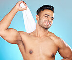 Face, skincare and body of man with towel in studio isolated on a blue background. Thinking, cleaning and personal hygiene of male model from Brazil with cotton cloth to wipe after shower or bathing.