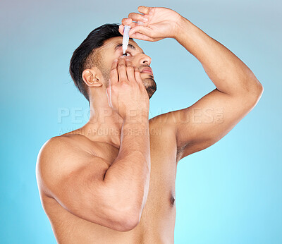 Buy stock photo Man, eye drops and vision in studio for healthcare, eyesight and medical product for allergies. Shirtless model, liquid solution and eyes to stop allergy, self care and wellness by blue background