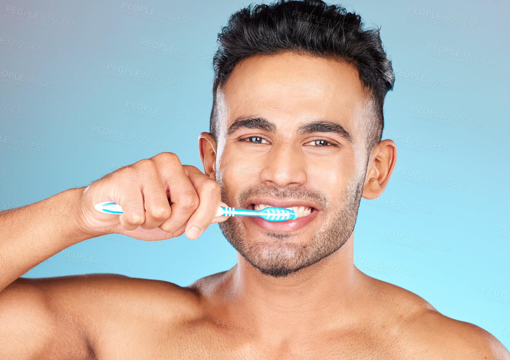 Buy stock photo Face portrait, dental and man brushing teeth in studio isolated on a blue background. Wellness, oral health and routine of happy male model holding toothbrush for hygiene, oral care and dental care.