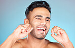Floss, Mexican man and dental health for smile, fresh breath and after brushing teeth against blue studio background. Oral health, Latino male and string to clean mouth, hygiene and morning routine.