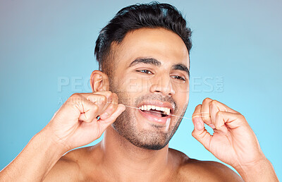 Buy stock photo Floss, Mexican man and dental health for smile, fresh breath and after brushing teeth against blue studio background. Oral health, Latino male and string to clean mouth, hygiene and morning routine.