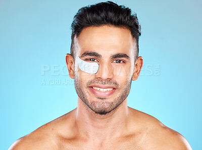 Buy stock photo Portrait, face and eye mask with a man model in studio on a blue background for antiaging skincare. Product, wellness and beauty with a handsome young male using cosmetic treatment for dermatology