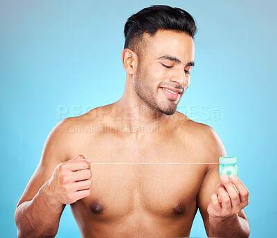 Buy stock photo Man, body or dental floss for grooming, mouth hygiene maintenance or plaque removal help on blue background in studio. Smile, happy or flossing model and teeth product in healthcare wellness cleaning