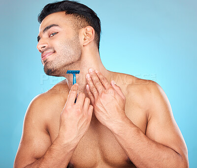 Buy stock photo Shaving, grooming and man with a razor for a beard, skincare and hygiene against a blue background in studio. Cosmetic, health and model with a smile to shave hair from face for clean facial beauty