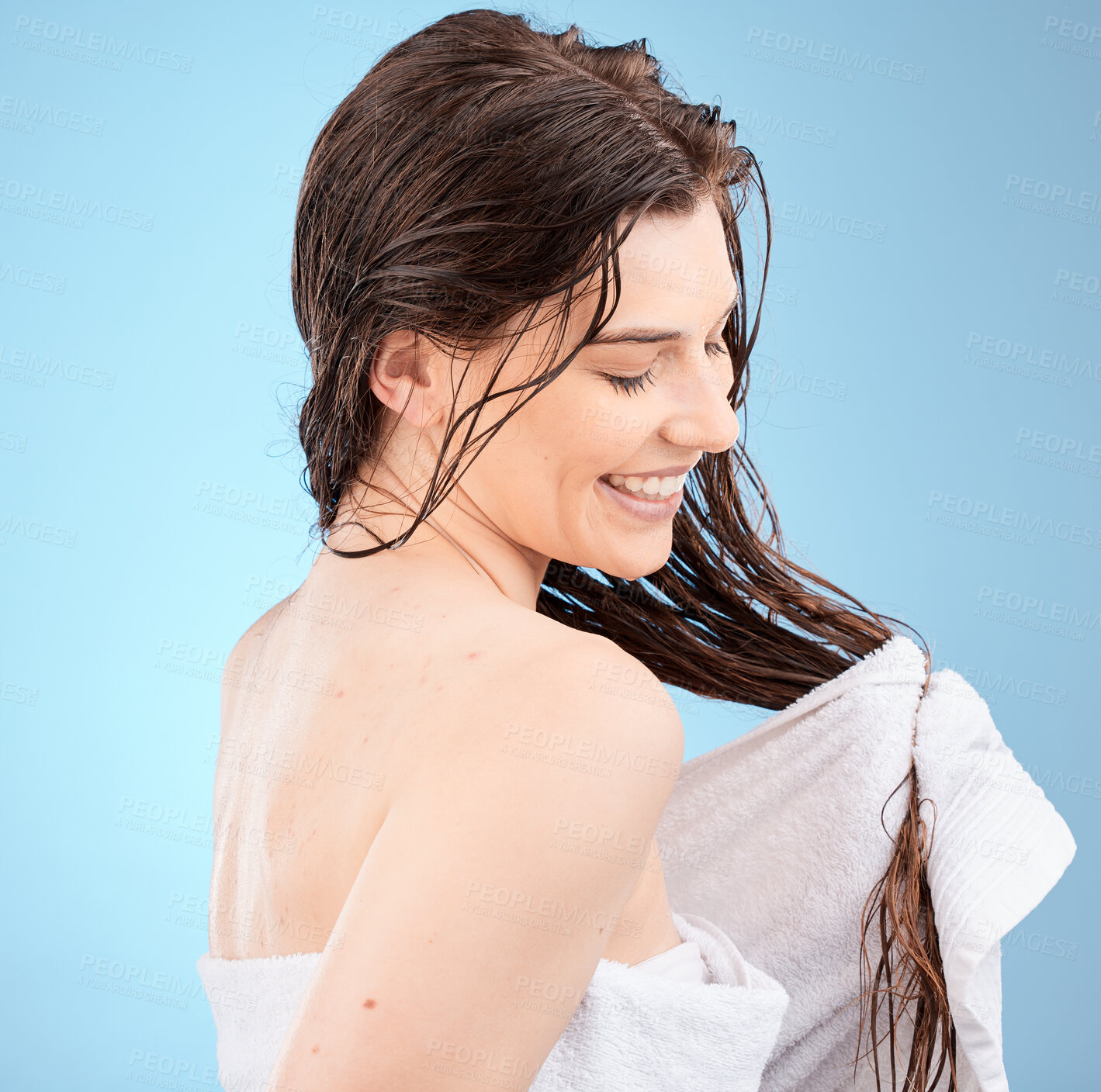 Buy stock photo Haircare, washing and cleaning hair and a woman drying her hair with a towel on a blue studio background. Salon, hair style and hair care with a clean female after hair wash with wet hair