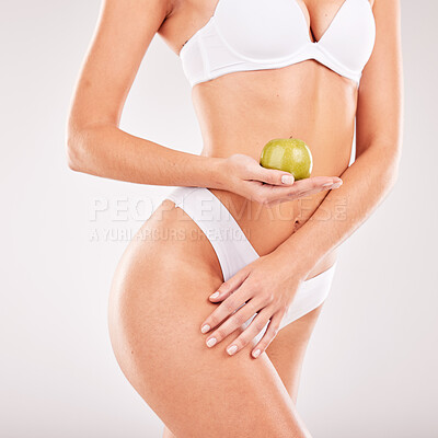 Buy stock photo Lingerie, skincare and body of woman with apple in studio isolated on a gray background. Underwear, food and female model holding fruit for nutrition, vitamin c or healthy diet, body care or beauty.