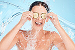 Woman, skincare and cucumber cosmetic water splash for skin care nutrition, health and natural wellness mockup. Healthy beauty model, happy face and advertising facial healthcare on a blue background