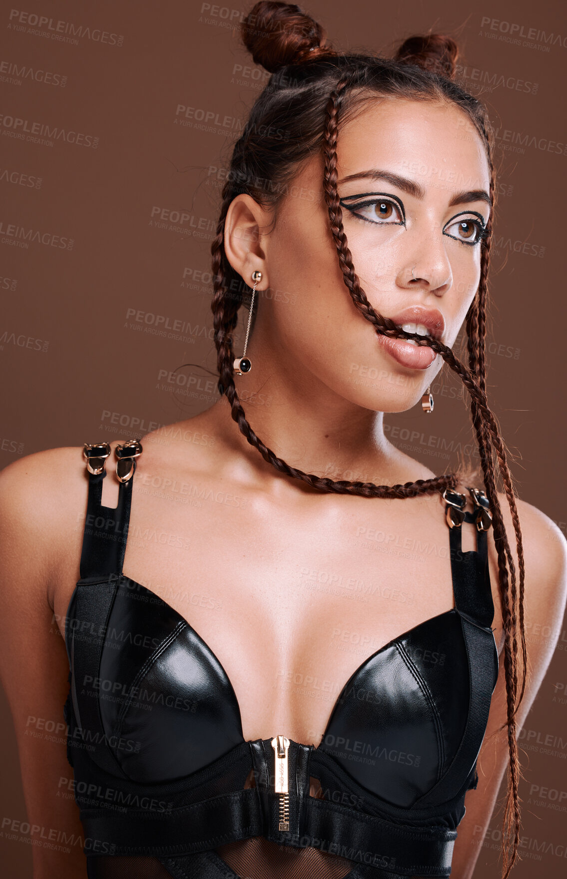 Buy stock photo Fashion, edgy and sexy girl thinking with seductive bite and attractive black eyeliner makeup. Aesthetic, trendy and sensual black woman with cool leather clothing on brown studio background.
