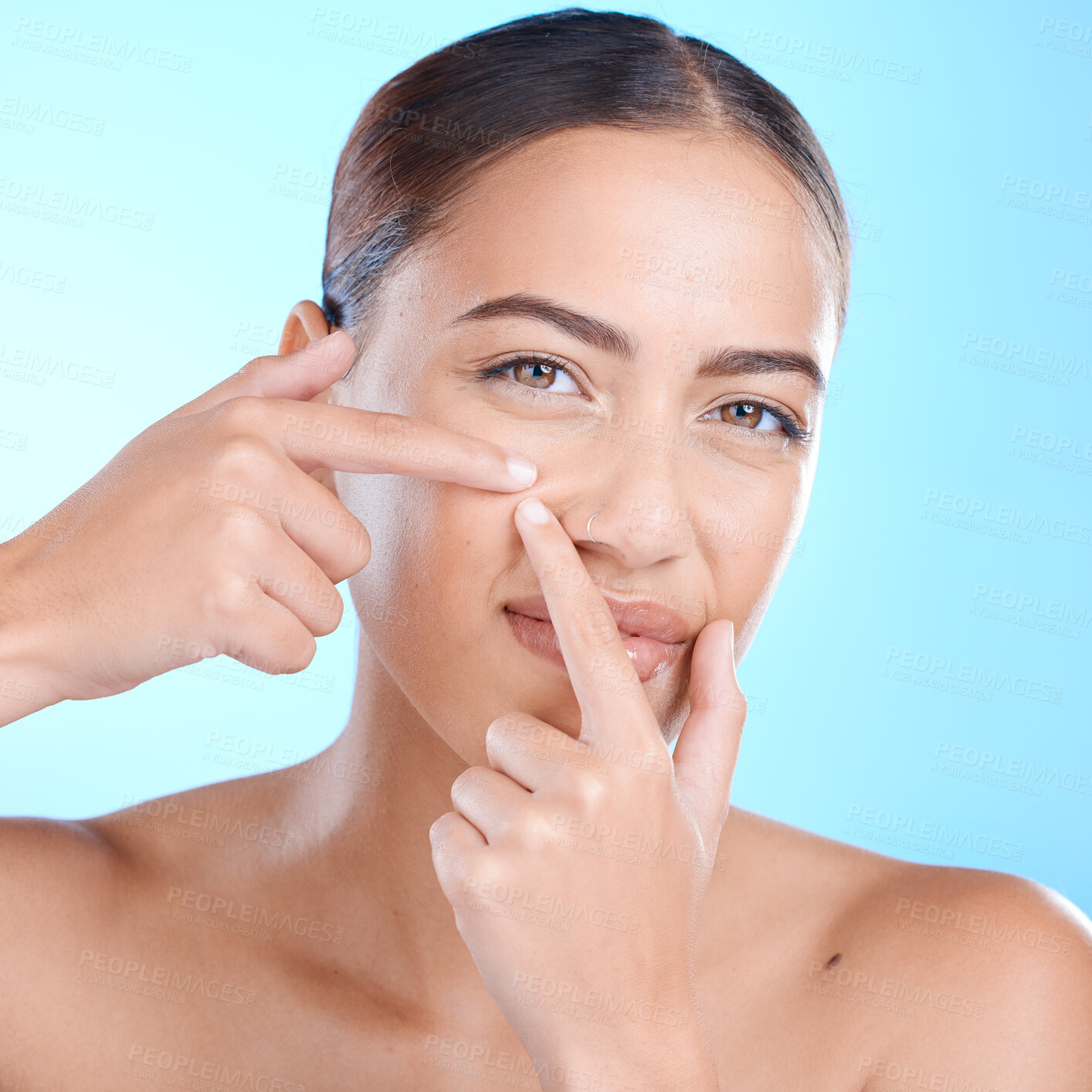 Buy stock photo Skincare, portrait and woman squeeze a pimple in a studio for a natural facial treatment. Beauty, cosmetic and girl model from brazil with a face acne routine for health isolated by a blue background