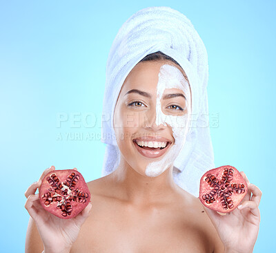 Buy stock photo Face mask, beauty skincare and woman with pomegranate in studio isolated on a blue background. Half facial mask, spa treatment and female model holding fruits for nutrition, vitamin c or healthy diet