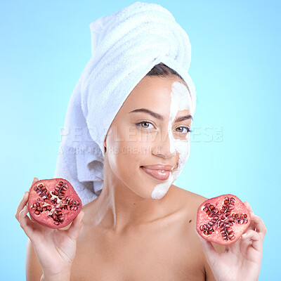 Buy stock photo Beauty cream, face and woman with pomegranate, skincare and vitamin c for health, wellness and towel after shower in blue studio background. Model portrait, fruit and skin care, detox or clean facial