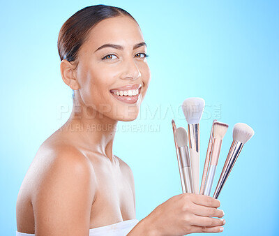 Buy stock photo Skincare, beauty and makeup brush for portrait, cosmetics and foundation for glow, smile and happiness on face with blue studio background. Aesthetic Colombia model with beautician or makeover tools