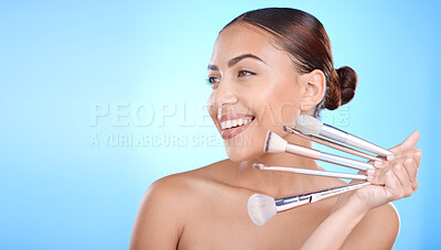 Buy stock photo Beauty, woman with makeup and brush in hand with cosmetic tools advertising, foundation and powder against blue background. Model with smile for wellness, skincare and face cosmetics care mockup.