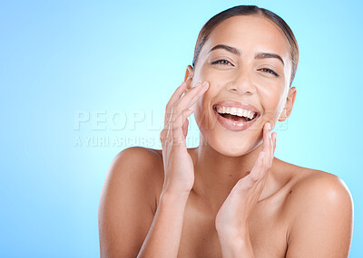 Buy stock photo Beauty, skincare and face of a woman with a smile, glow and happiness on blue studio background for makeup, cosmetics and dermatology. Portrait of Colombia model touching soft, clean and healthy skin