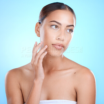 Buy stock photo Woman, skincare and touching face with hands on blue background in studio for dermatology healthcare, self love or acne treatment progress. Brazilian beauty model, facial makeup cosmetics or manicure