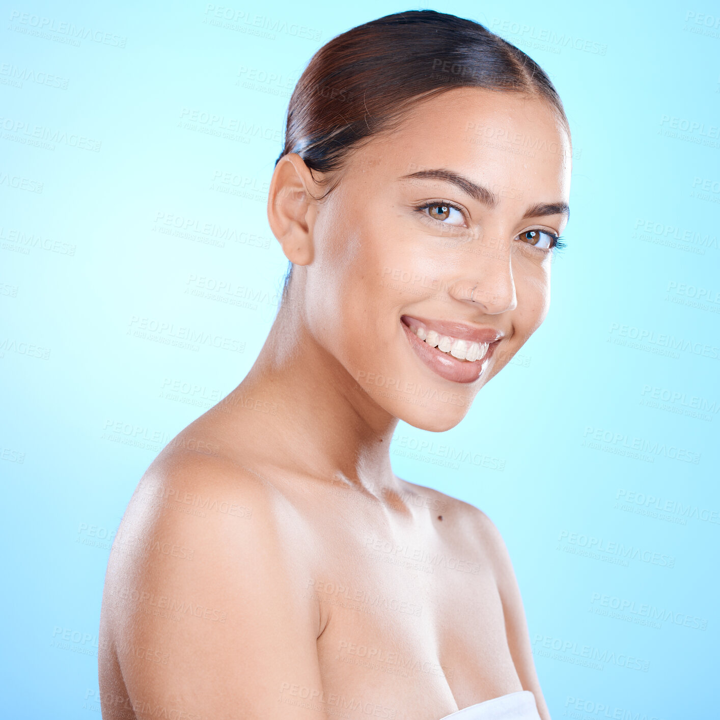 Buy stock photo Skincare, woman and cosmetics for wellness, smile and  treatment against a blue studio background. Portrait, makeup and Latino girl with natural beauty, clear and smooth for organic facial and relax.