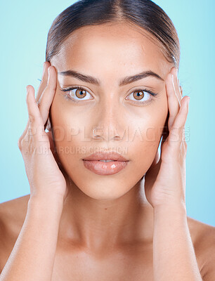 Buy stock photo Portrait, face and beauty with a model black woman touching her skin in studio on a blue background. Skincare, cosmetics and antiaging with an attractive young female posing for natural treatment