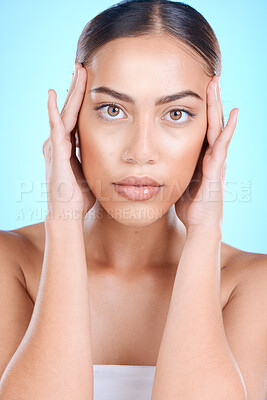 Buy stock photo Woman, skincare or touching face with hands on blue background in studio for dermatology self love, anti aging treatment or collagen. Facial portrait, Brazilian beauty model or eyes makeup cosmetics