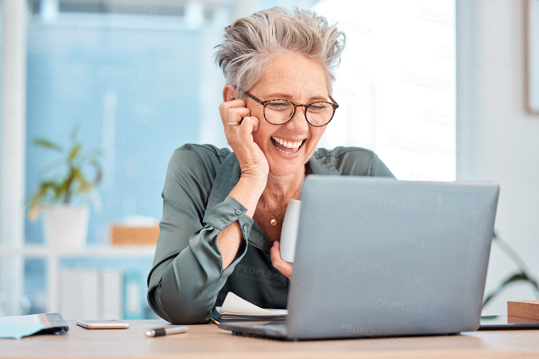 Buy stock photo Laptop, coffee and senior business woman laughing at an email in her office at work for fun or humor. Computer, tea and comic with a mature female employee working on a report or project and joking