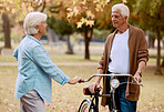 Love, bike and park with a senior couple on a date together during summer while enjoying retirement. Nature, dating and romance with a mature man and woman outdoor in a garden for bicycle bonding