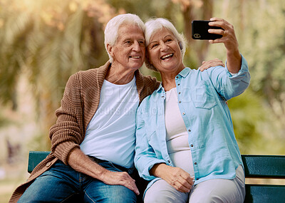 Buy stock photo Senior couple, phone selfie and smile on park bench for love, care and social media profile picture of a happy retirement. Old man and woman outdoor together for happiness, support and bonding