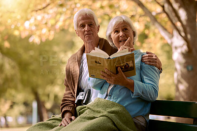 Buy stock photo Couple, elderly and reading a book in park, travel and outdoor during retirement with relationship and spending quality time together. Man, woman and relax on park bench, talk with view in New York.