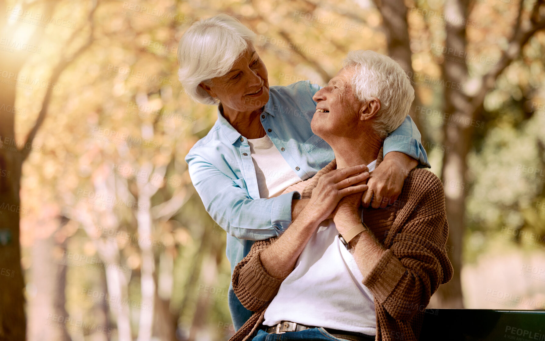 Buy stock photo Love, nature and mockup with a senior couple on a park bench to relax during retirement together. Smile, romance and summer with a mature man and woman hugging or bonding outdoor in a spring