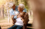Love, senior couple and hug in park on bench, bonding and romantic together outdoor. Romance, mature man and elderly woman embrace, loving or happy for relationship, marriage and retirement in nature
